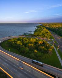 Aerial view of a two lane highway interchange with the ocean in the background