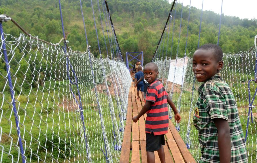 Kids crossing a footbridge in Rwanda